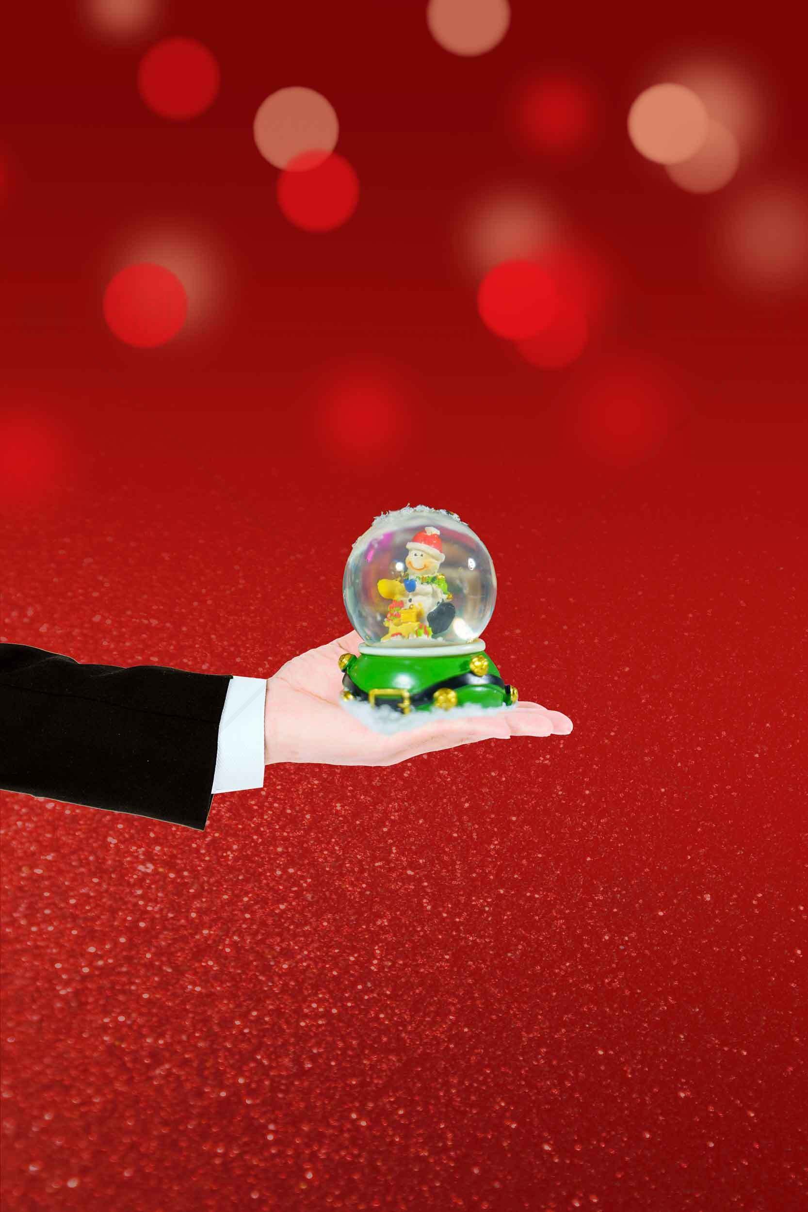圣诞节红色背景手握雪花球图片素材